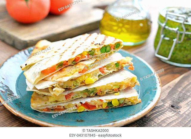 Stack of mexican Quesadilla with chicken, corn, sweet pepper and tomato closeup