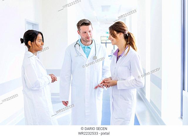 Doctor and coworkers talking in hospital corridor