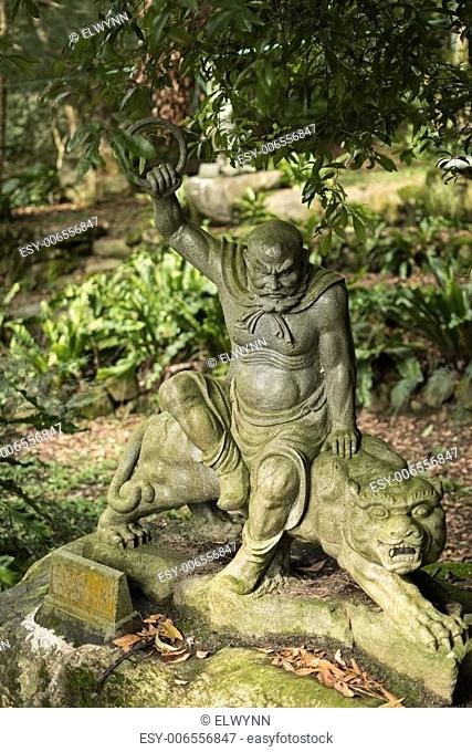 Old ruined Arhat Kanakbharadvaja statue in forest, Taiwan, Asia