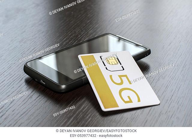 SIM card and mobile phone on table
