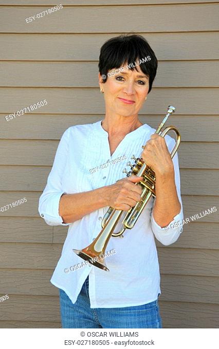 Mature female beauty with her trumpet outdoors