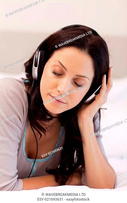 Woman laying on her bed enjoying music
