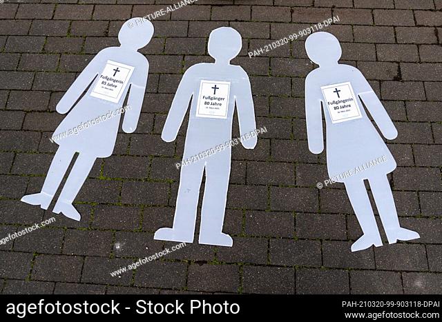 20 March 2021, Saxony, Leipzig: Three symbolically represented victims lie on the ground for the vigil of the pedestrian association Fuss e.V