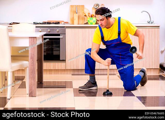 The young male contractor repairing tap at home