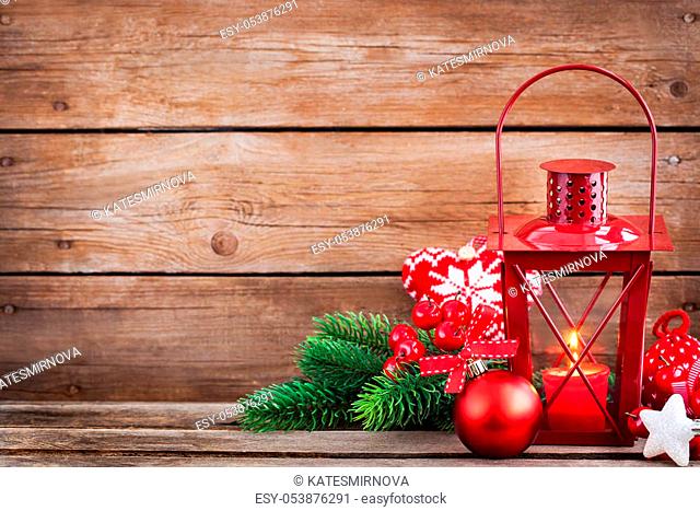 Christmas time red latern with candle light and holiday decorations around, copy space