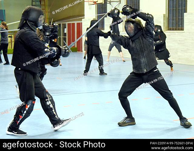 08 September 2022, Saxony, Leipzig: Historical fencing with long swords is practiced in a gymnasium by men and women under the guidance of fencing instructor...
