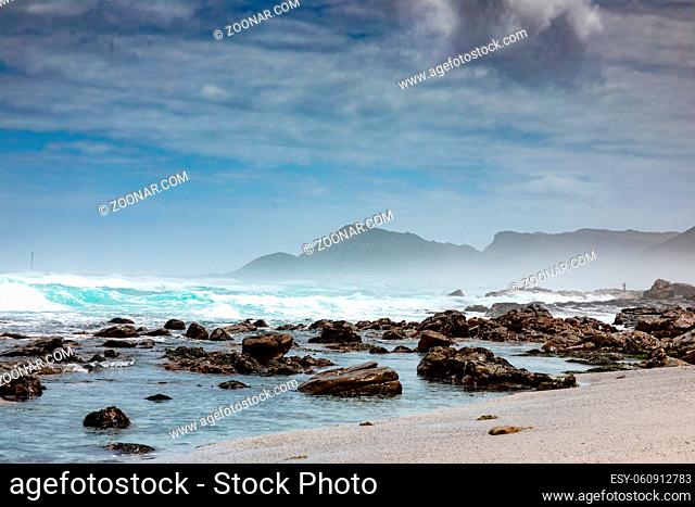Sandy beach on western side of Cape Town peninsula on a cloudy day