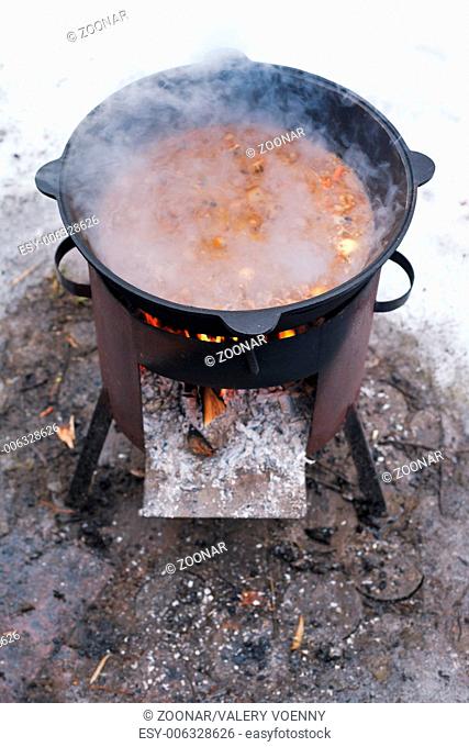 food stewed in cauldron on mobile brazier