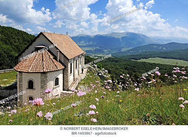 Hikers at the church Santa Maria di Monte Tranquillo, Villetta Barrea, National Park of Abruzzo, Italy, Europe
