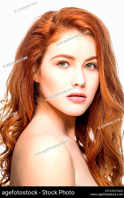 beautiful young woman with long healthy shiny wavy red hair. copy space. isolated on white background
