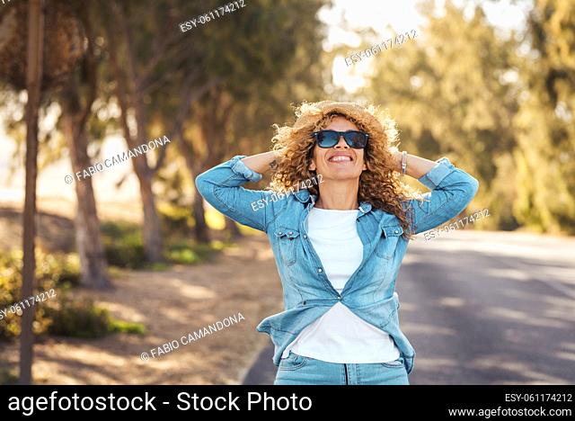 Happy and enjoyed cheerful pretty adult woman in outdoor leisure activity. Portrait of excited female people smiling and having fun walking on the road with...