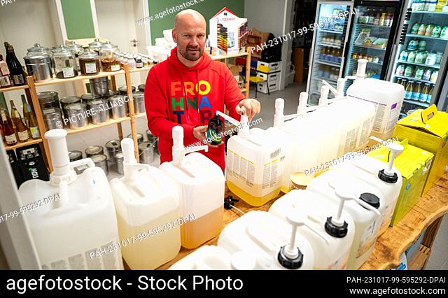 11 October 2023, Lower Saxony, Reppenstedt: Malte Melloh, founder of the unpackaged store ""FrohNatur, "" bottles washing lotion