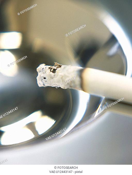 A lit cigarette on an ashtray, Close Up, High Angle View, Differential Focus