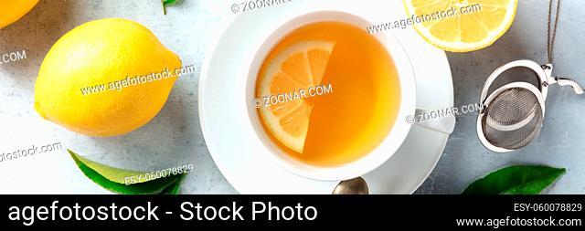 Lemon tea panorama, shot from the top. Organic lemons and a cup of the healthy natural drink, a flat lay panoramic banner