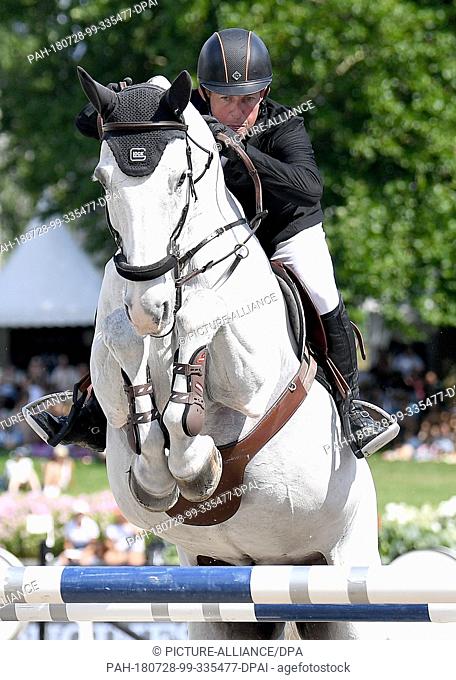 28 July 2018, Germany, Berlin: equestrian sports/jumping: Global Champions Tour: Gerco Schroeder from the Netherlands and Glock's Cognac Champblanc jump over an...