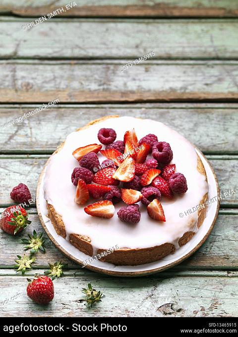 Vegan summer cake with strawberries, raspberries and icing