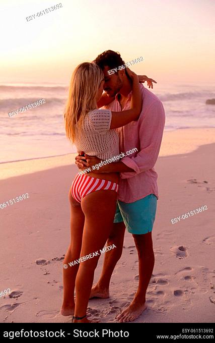 Caucasian couple enjoying time at the beach during the sunset