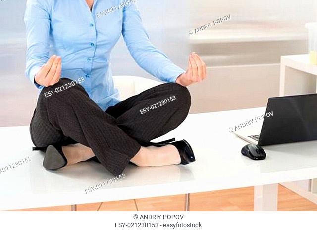 Close-up Of Businesswoman Doing Yoga In Office