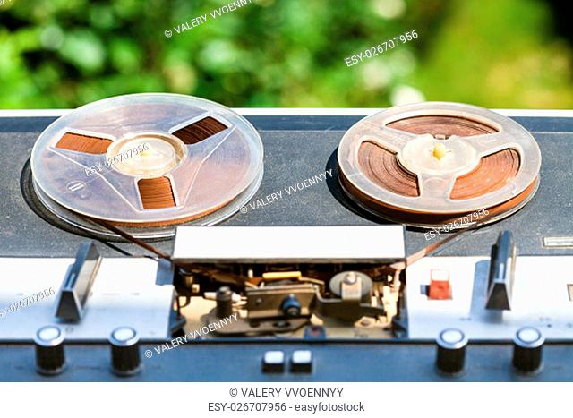 shabby reel-to-reel recorder with in reels outdoors