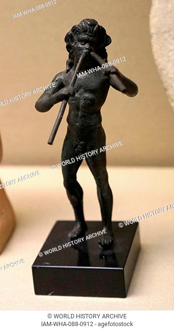 Bronze figure of a satyr playing double-pipes. Dated 1st Century
