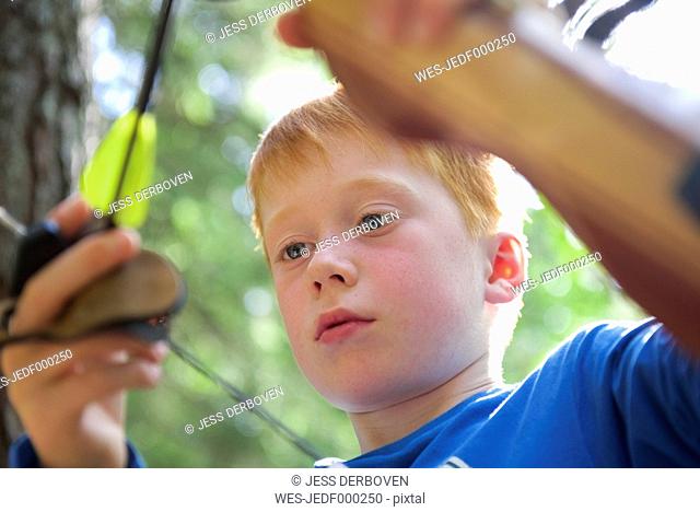 Portrait of a boy with a bow in an adventure park