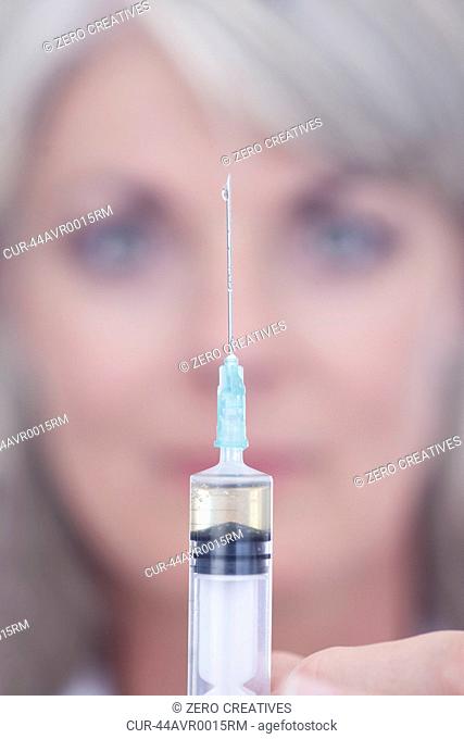 Scientist squeezing drop out of syringe