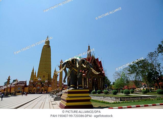 04 March 2019, Thailand, Ao Luek Distrikt: An elephant statue and in the background the Chedi of Wat Maha That Wachira Mongkol or Wat Bang Tong