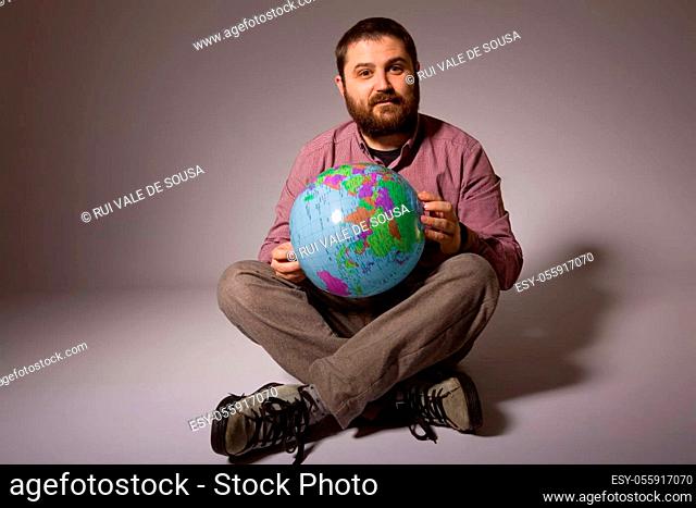young casual man full body with a globe