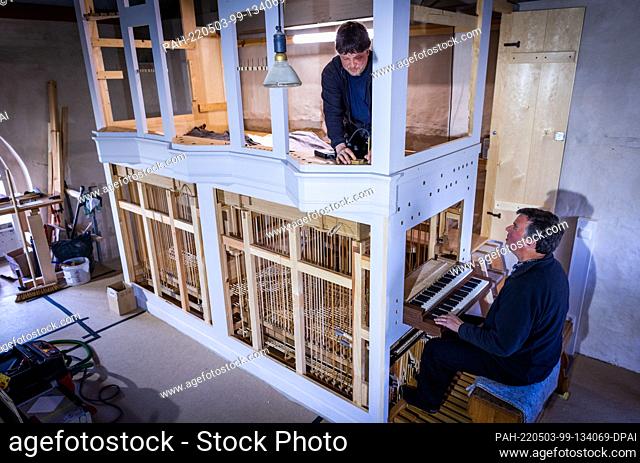 02 May 2022, Mecklenburg-Western Pomerania, Pinnow: Christian Mrzik (above) and Michael Dittrich work on the new organ for the 14th century village church