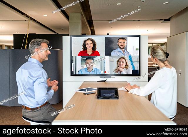 Businessman and businesswoman having a video conference in office