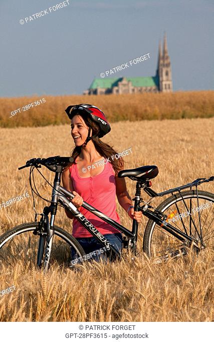 BICYCLE TOURISTS IN A WHEAT FIELD NEAR THE CHARTRES CATHEDRAL, EURE-ET-LOIR 28, FRANCE