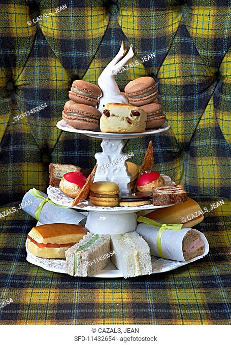 Sandwiches and macaroons on a vintage cake stand for teatime