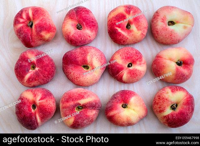 Flat lay of 12 fresh ripe saturn peach