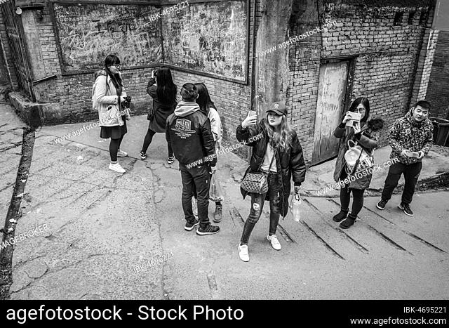 Street scene in an old town quarter of Chongqing. Students photograph scenes from a popular television series. These neighborhoods are gradually being...