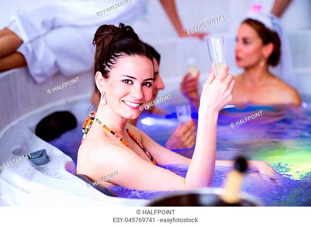 Cheerful bride and happy bridesmaids in bikinis celebrating hen party in wellness center. Women enjoying a bachelorette party