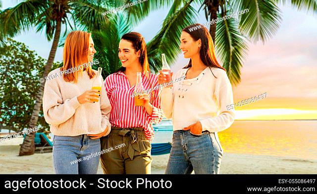 young women with non alcoholic drinks on beach