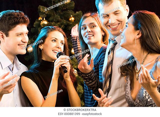 Portrait of five friends having fun at karaoke party