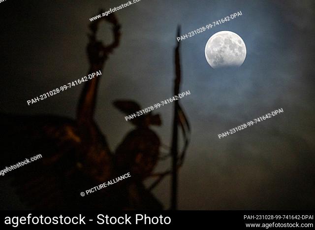 28 October 2023, Berlin: A partial lunar eclipse can be seen behind the Gold Else on the Victory Column. A lunar eclipse occurs when the Earth's shadow in space...