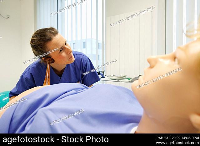 20 November 2023, Lower Saxony, Osnabrück: Trainee midwife Judith Brinkers works with a Pinard tube on the dummy of a woman giving birth in the simulation lab...