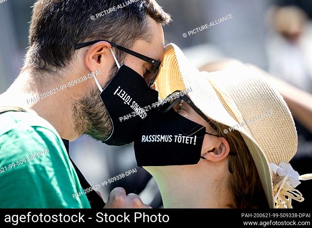21 June 2020, Thuringia, Erfurt: A man and a woman wear a black face mask with the inscription ""Racism kills!"" at a demonstration under the motto...