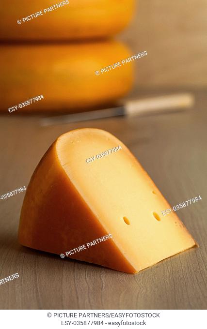 Piece of fresh cut Dutch Gouda cheese in a shop