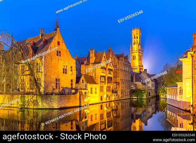 Historic medieval buildings along a canal in Bruges, Belgium at dusk