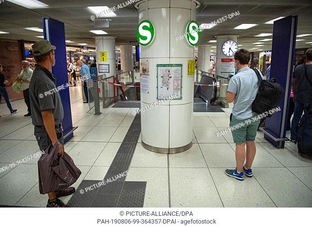 06 August 2019, Bavaria, Munich: Travellers stand in front of a closed S-Bahn entrance in the main station. S-Bahn traffic in the center of Munich was...