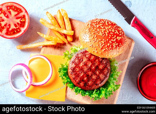 Burger ingredients, overhead flat lay shot with French fries and a barbecue sauce. Hamburger and potatoes, shot from the top