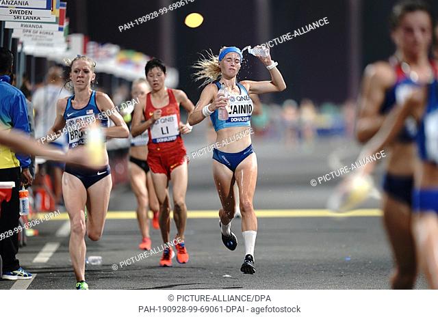 28 September 2019, Qatar, Doha: Athletics, World Championships, Marathon, Women. Alisa Vaino from Finland and other runners will receive drinks and water