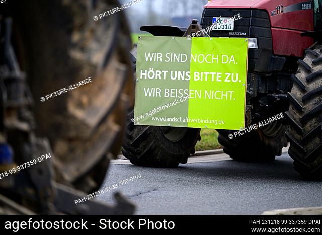 18 December 2023, Lower Saxony, Uelzen: ""We are still here. Please listen to us. We won't bite"" is written on a tractor driving at walking pace with others on...