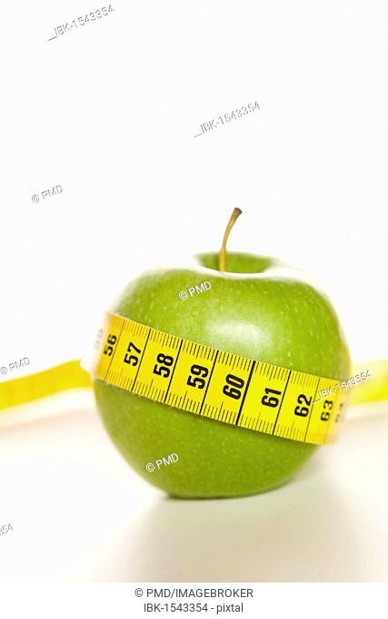 Green apple with a yellow tape measure