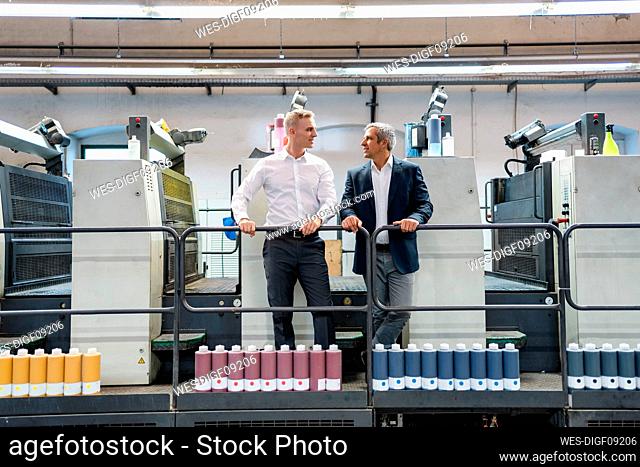 Two businessmen talking in a printing shop