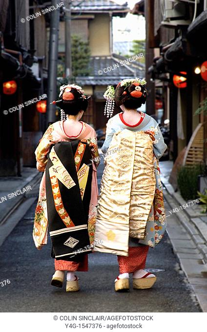 Two geisha walking away from camera in narrow street Gion Kyoto