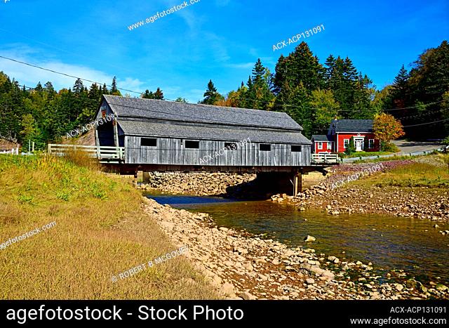 A side view of an iconic covered bridge built in 1946 crossing the Irish river at Hardscrabble, in Saint Martins, New Brunswick, Canada